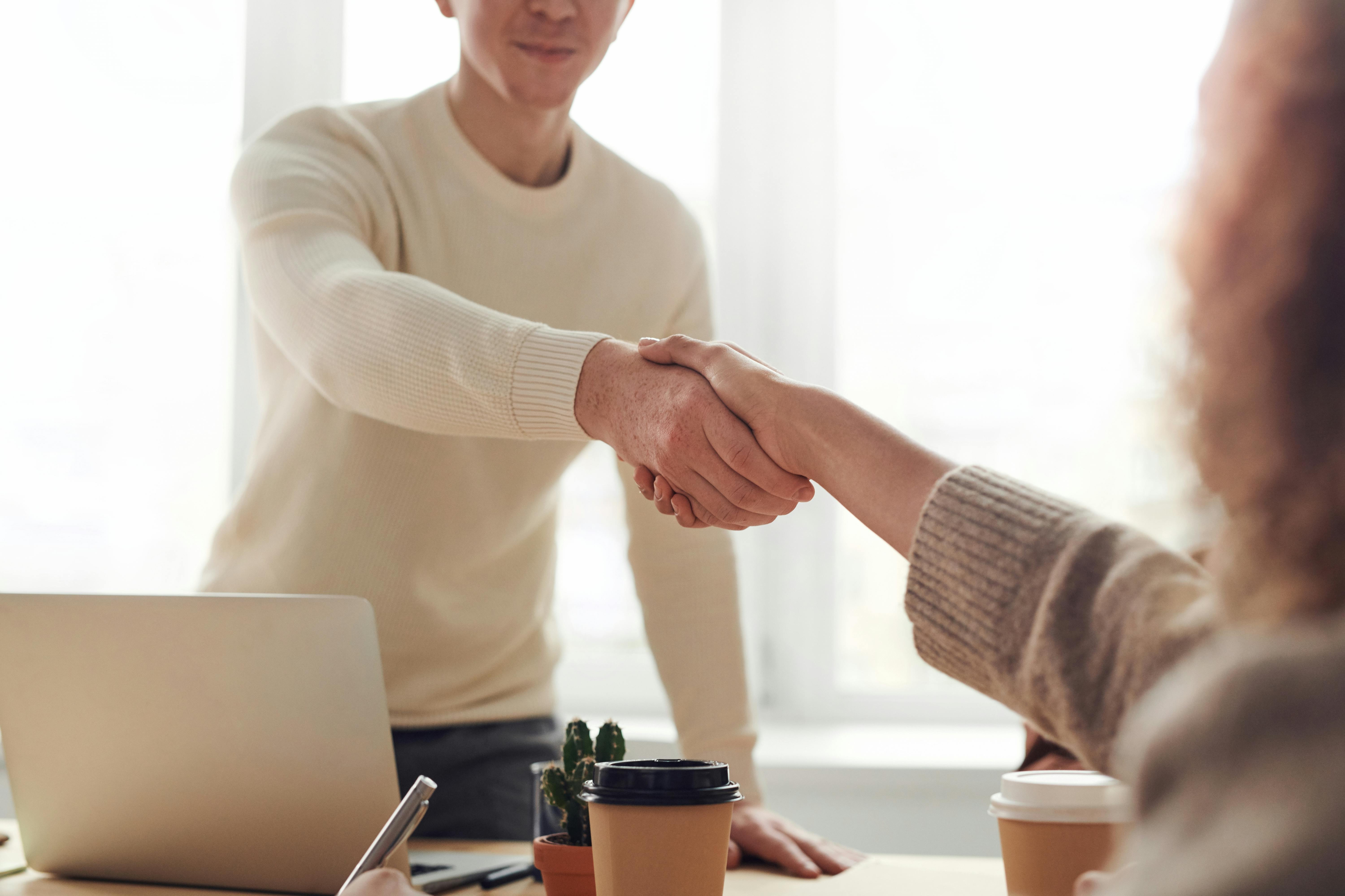 Brand partnership: Business collaboration meeting with handshake over gaming project.
