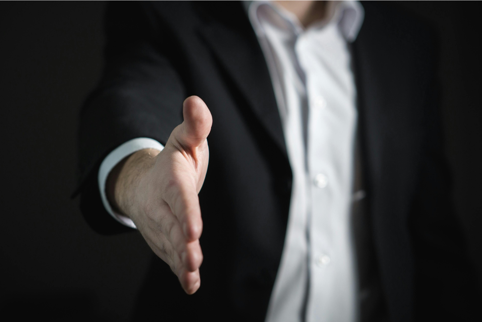 Person’s hand reaching out in a handshake gesture, representing the role of partnership specialists