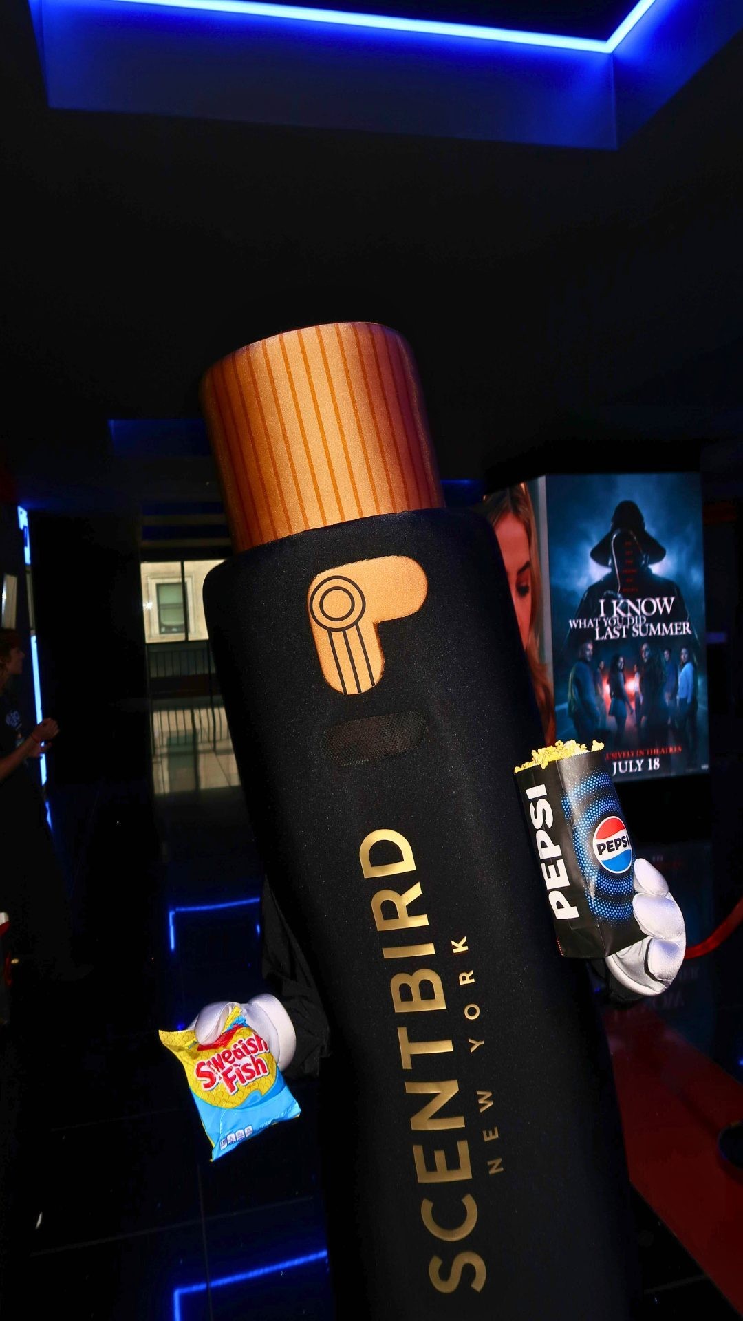 Misty the Scentbird mascot holding candy and popcorn.