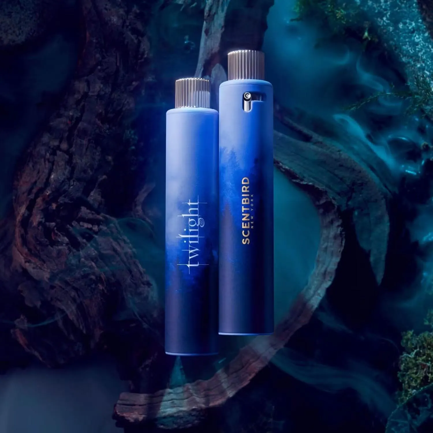 Twilight x Scentbird fragrance collaboration featuring two blue perfume atomizers displayed against a dark, cinematic forest-inspired background. One bottle is labeled “twilight” while the other features Scentbird branding, with smoky blue lighting and textured tree elements creating a mysterious, fantasy-inspired atmosphere.